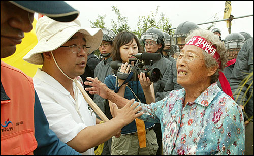 10일 오후 경기도 평택 대추리 대추초등학교에서 열릴 예정인 '미군기지 확장 저지와 한반도 전쟁반대 7.10 평화대행진'에 참석하기 위해 전국각지에서 출발한 시민단체 회원과 대학생들이 속속 도착하고 있다. '미군기지 확정 결사반대' 구호가 적힌 머리띠를 두른 할머니가 집회장입구에서 외지 참가자들을 반갑게 맞이하고 있다. 